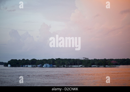 Sonnenuntergang über dem Amazonas, wie Boote-Moor auf einer Insel vor ein Sturm in rollt Stockfoto