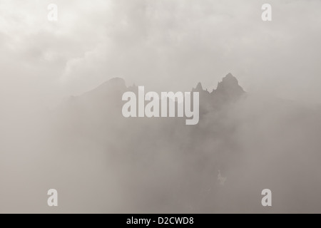 Nebel und Wolken um die 3000 Meter vertikale Trollmauer und die Spitzen Trolltindane, im Tal Romsdalen, Østfold, Norwegen. Stockfoto