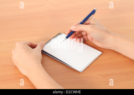 Frau Hände schreiben in einem Notebook auf einem Tisch in einem weißen Hintergrund isoliert Stockfoto