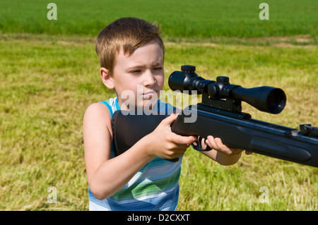 kleiner Junge mit dem Ziel, auf der Suche in den Anwendungsbereich der sein Gewehr Stockfoto