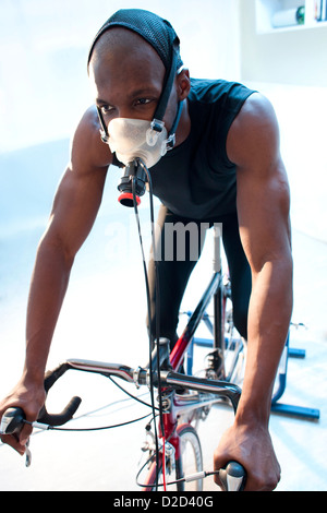 MODEL Release Leistungstests Athlet einen Heimtrainer zu reiten, während seine Leistung und Sauerstoffverbrauch gemessen werden Stockfoto