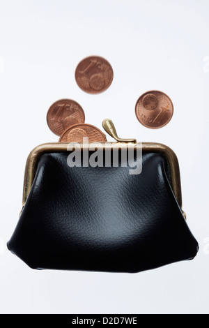 Münzen fallen in Handtasche Stockfoto
