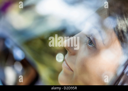 Eine junge Frau schaut nachdenklich aus dem Fenster von einem stationären Auto Stockfoto