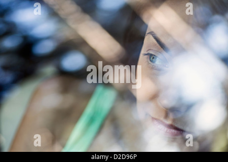 Eine junge Frau schaut nachdenklich aus dem Fenster von einem stationären Auto Stockfoto