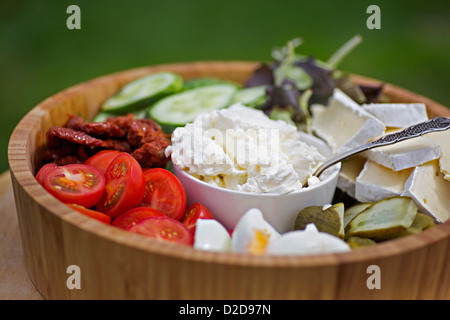 Eine hölzerne Salatschüssel mit verschiedenen Gemüse und Käse gefüllt Stockfoto