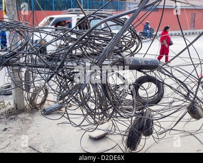 Elektriker arbeitet an einem Gewirr von elektrischen Leitungen in Kathmandu, Nepal. Stockfoto