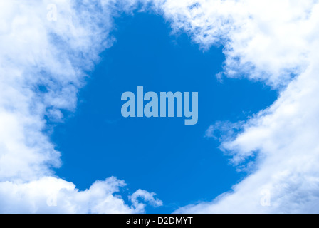 Wolken am Himmel haben ein Fenster gebildet, durch die der dunkelblauen Himmel sichtbar ist Stockfoto