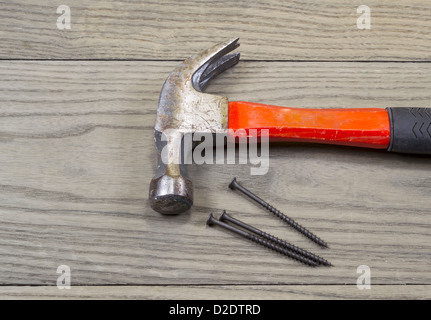 Alten Hammer und Holz Schrauben liegen oben auf hölzernen Terrassendielen Stockfoto