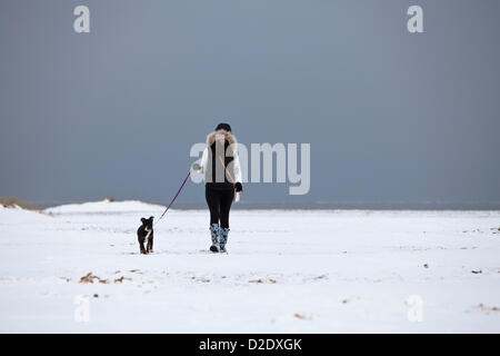 Great Yarmouth, UK. 21. Januar 2013. Junge Frau zu Fuß ihren Hund über den "weißen Strand" von Yarmouth nach Schneefall an der Ostküste entlang. Stockfoto