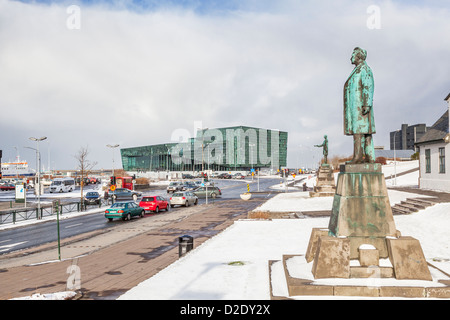 In Reykjavik, Island, mit Harpa (Konzertsaal) Hintergrund, im Schnee im Winter mit Statue von Hannes Hafstein Vordergrund anzeigen Stockfoto