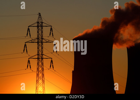 Hochspannungs-Turm und Kraftwerk während des Sonnenuntergangs Stockfoto