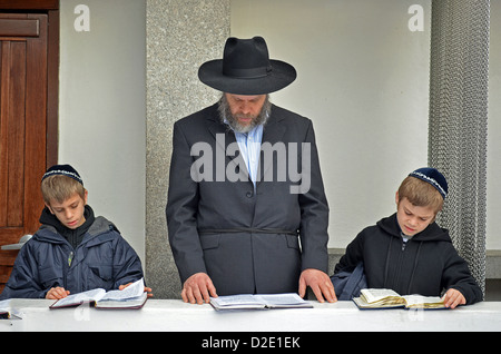 Eines religiösen jüdischen Vaters & seine 2 Söhne beten an den Gräbern von den letzten beiden Lubawitscher Rebbes in Cambria Heights, Queens, New York Stockfoto