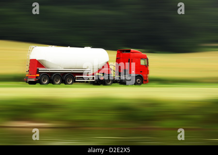 große weiße Zisterne LKW Beschleunigung auf der Autobahn mit unscharfen Landschaft Panorama im Hintergrund Stockfoto