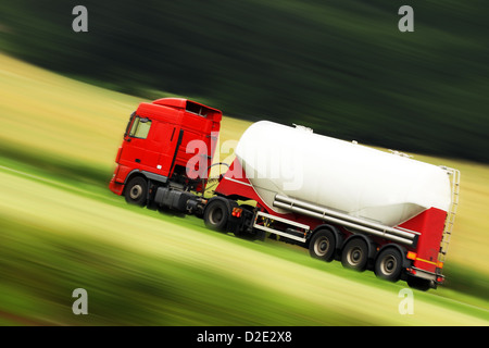 große weiße Zisterne LKW Beschleunigung auf der Autobahn mit unscharfen Landschaft Panorama im Hintergrund Stockfoto