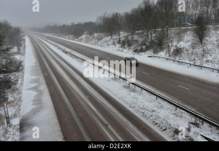 Ein Auto bewegt sich entlang einer tief verschneiten Autobahn in Shropshire, England Stockfoto