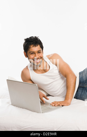 Mann auf einem Laptop arbeiten und lächelnd Stockfoto
