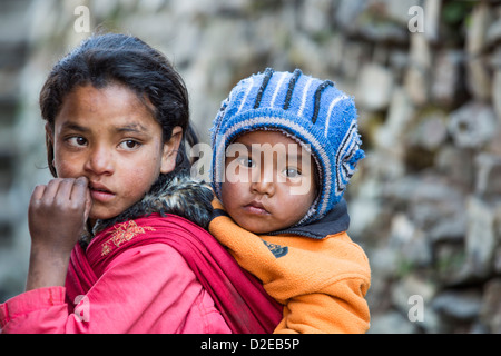 Nepalesische Mädchen mit ihrem kleinen Bruder im Himalaya, Nepal. Stockfoto