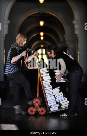 Festivalorganisatoren manövrieren einen Stapel Bücher auf einem Sack-LKW auf dem Cheltenham Literaturfestival UK Stockfoto