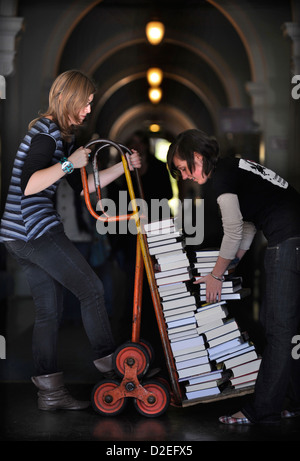 Festivalorganisatoren manövrieren einen Stapel Bücher auf einem Sack-LKW auf dem Cheltenham Literaturfestival UK Stockfoto