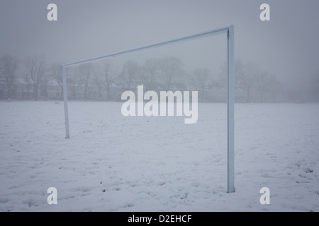 Ein Fußballplatz und leere Landschaft mit verschneiten Torpfosten im winterlichen öffentlichen Park in Süd-London. Während einer längeren Kälteperiode des schlechten Wetters fiel Schnee kontinuierlich auf das Kapital am Sonntag, so dass Familien die Möglichkeit, die trostlosen Bedingungen genießen hier in Ruskin Park im Stadtteil Lambeth. Die Fußball-Torpfosten gehört ein Fußballfeld verwendet durch lokale Teams sonst ungenutzt wie das Wetter zwingt lokale Spiele abgebrochen werden, bevor der Rasen unter wieder aufgedeckt wird. In der Ferne sind Edwardian Periode Häuser unter 100 Jahre alten Eschen. Stockfoto