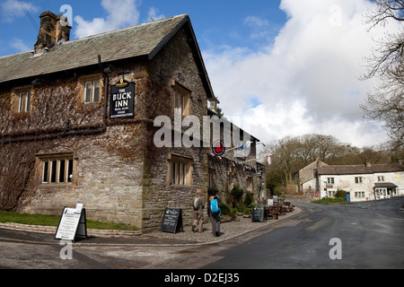 Spaziergänger, die am „Buck Inn“, Malham, Grassington, North Yorkshire Dales, Großbritannien, vorbeikommen Stockfoto