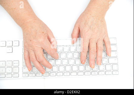 Hände einer alten Frau, die Eingabe auf der Tastatur, isoliert auf weiss, Nahaufnahme. Stockfoto