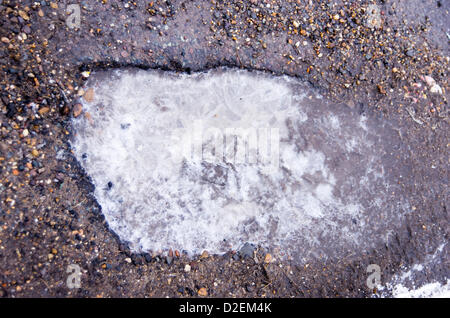 Große Bardfield, Essex, England. 22. Januar 2013. Winter Wetter Schäden Straßen als unrepariert Schlaglöcher füllen sich mit Wasser, das über das Einfrieren, bricht die Oberfläche erweitert. Stockfoto