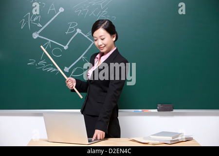 Lehrerin mit Laptop im Klassenzimmer Stockfoto