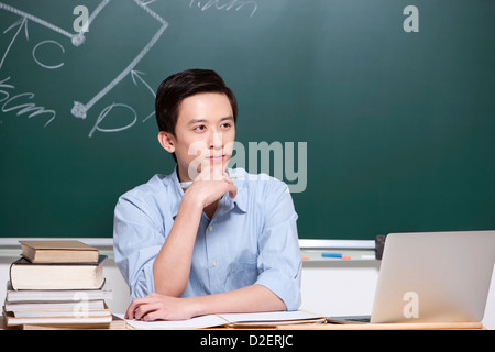Schweren männlichen Lehrer Hand am Kinn im Klassenzimmer Stockfoto