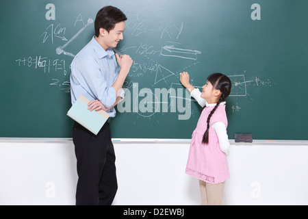 Glücklich Schulmädchen und Lehrer im Klassenzimmer, von Angesicht zu Angesicht Stockfoto