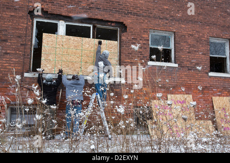 Über Martin Luther King Jr. Day Freiwillige aus der Wayne State University und Nachbarschaft Bewohner mit Brettern vernagelt verlassenen Häusern. Stockfoto