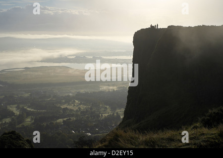 Menschen, die Silhouette auf nebliger Morgen auf Cavehill mit Belfast stehen im Hintergrund Stockfoto