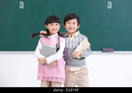 Schülerinnen und Schüler gemeinsam ein Buch zu lesen, im Klassenzimmer Stockfoto