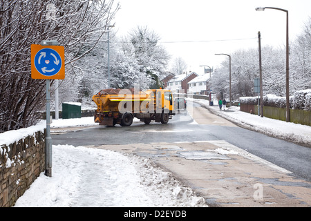 Salzstreuer LKW behandeln Dorfstraße in West Yorkshire auf Schnee und Eis im winter Stockfoto