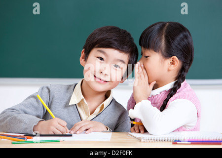 Nette Schüler Hausaufgaben im Klassenzimmer Stockfoto