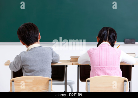 Schulkinder, die Hände in der Klasse Stockfoto