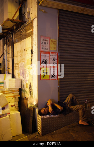 Hong Kong, China, Obdachloser schläft vor einem geschlossenen Geschäft Stockfoto