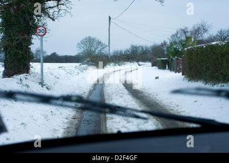 Die Sicht von innen, ein Auto der schneebedeckten Landstraßen in Norfolk, Großbritannien. 30 mph Höchstgeschwindigkeit Zeichen können auch auf dem Bild zu sehen ist. Stockfoto