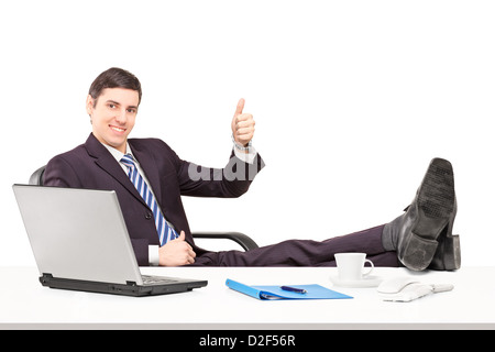 Junge Unternehmer sitzen auf einem Stuhl mit seinen Beinen und einen Daumen aufgeben isoliert auf weißem Hintergrund Stockfoto