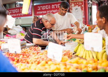 Markt Stall Besitzer bedienen Kunden im Hauptmarkt in Tel Aviv, Israel, am Tag vor dem Sabbat, dem jüdischen Ruhetag. Stockfoto