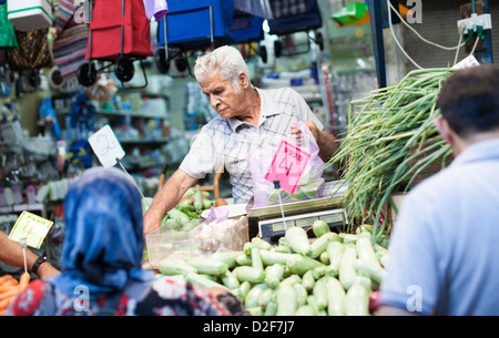 Markt Stall Besitzer bedienen Kunden im Hauptmarkt in Tel Aviv, Israel, am Tag vor dem Sabbat, dem jüdischen Ruhetag. Stockfoto