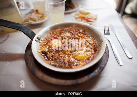 Eisenpfanne von Chakchouka serviert an Dr Shakshuka in Jaffa bei Tel Aviv in Israel. Das Gericht besteht aus Eiern, Tomaten und Gewürzen. Stockfoto