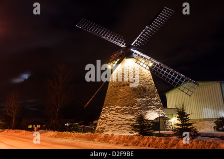 Bild der Nacht mit Mond von einer alten traditionellen Windmühle in einem Feld unter dem Schnee (in der Nähe von Tallinn, Estland) Stockfoto