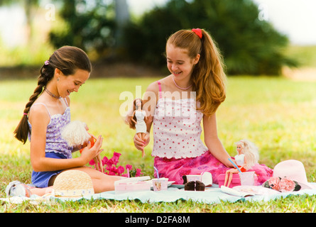 Mädchen im Teenageralter spielen Barbie Puppen im Park, Picknick, Miami Stockfoto