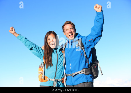 Glückliche junge Frau und Mann-Wanderer, Jubel bei gedrückter um einander mit gegen Himmel erhobenen Armen Stockfoto