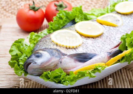 Frischer Fisch in Scheiben geschnittene Zitrone mit Gemüse Stockfoto