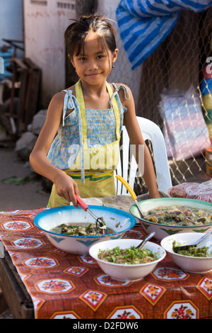 ein junges Mädchen Verkauf Lebensmittel in ein Morgenmarkt in Luang Prabang, Laos Stockfoto