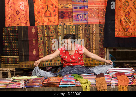 eine Frau verkaufen Stoff in ein Morgenmarkt in Luang Prabang, Laos Stockfoto