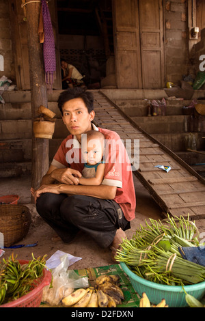 Verkäufer und sein Baby in ein Morgenmarkt in Luang Prabang, Laos Stockfoto