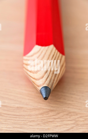Detail von der Spitze des roten Bleistift auf einem hölzernen Hintergrund hautnah Stockfoto